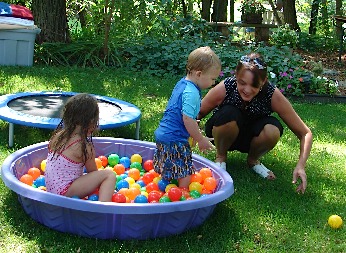 Kids playing in their ball pit outside
