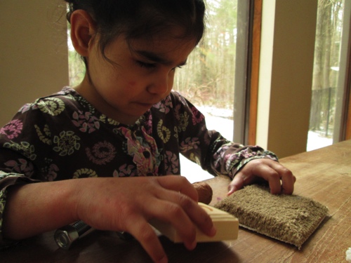 Anelia touching wood and carpet.