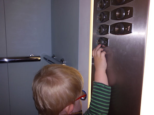 Enzo touching the buttons and the braille in an elevator