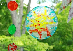Four circle suncatchers with stained glass appearance hanging in the window