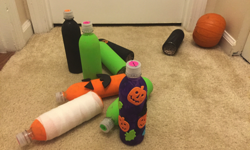 Bottle pins knocked over with pumpkin bowling ball