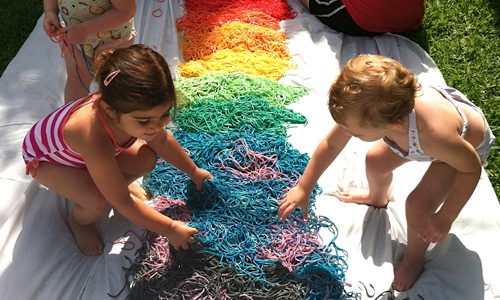 Kids playing with rainbow noodles