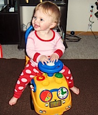 Abby riding on a toy bus