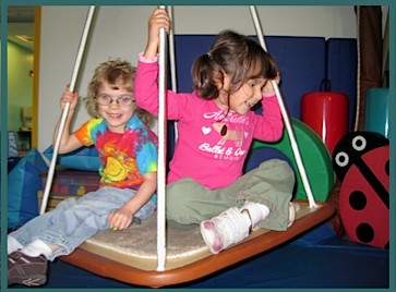 Ava and a friend enjoy the carpet swing together