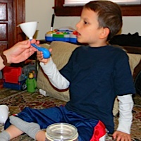 using a funnel to fill our balloon with rice