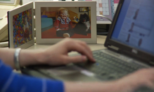 Catherine at work with a closeup of a framed picture of her daughter