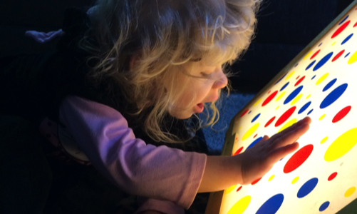 a little girl looking at a light box