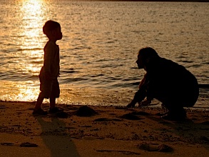 Mom and kid playing together on the beach