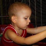 Ivan playing in a toy car at the mall.