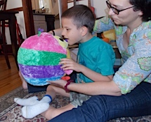 Ivan touching a big round stuffed animal