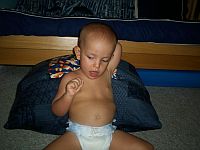 Ivan signs diaper while laying on his changing table.