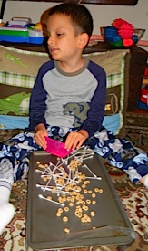 placing cheerios on the sticky canvas