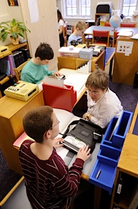 students in a classroom brailling