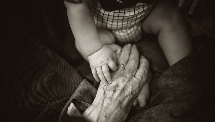 baby and grandmother touching hands