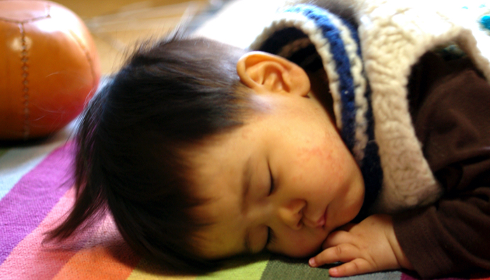 baby sleeping on a rainbow blanket