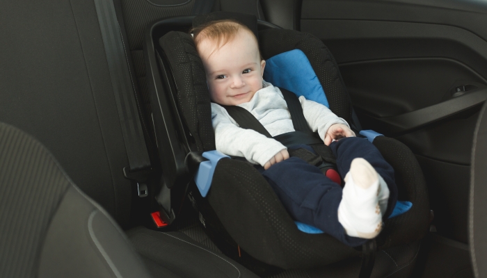 Cute 6 months old baby in car child seat.