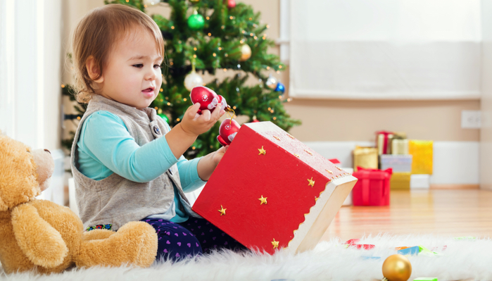 a little girl opening a christmas present