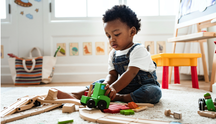toddler playing with a train set