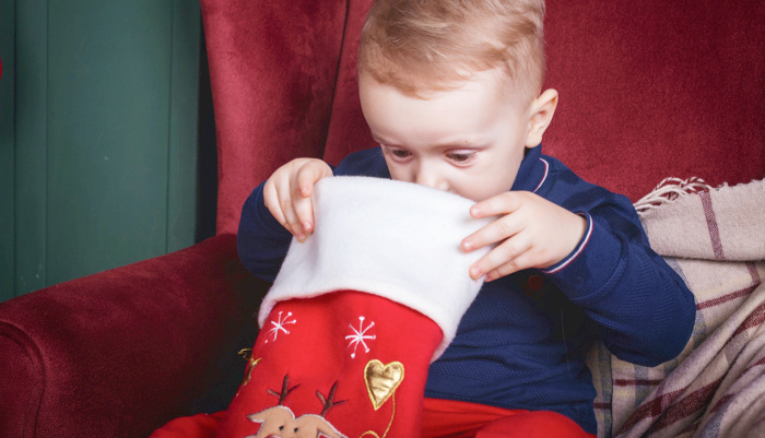 little boy looking in a Christmas stocking