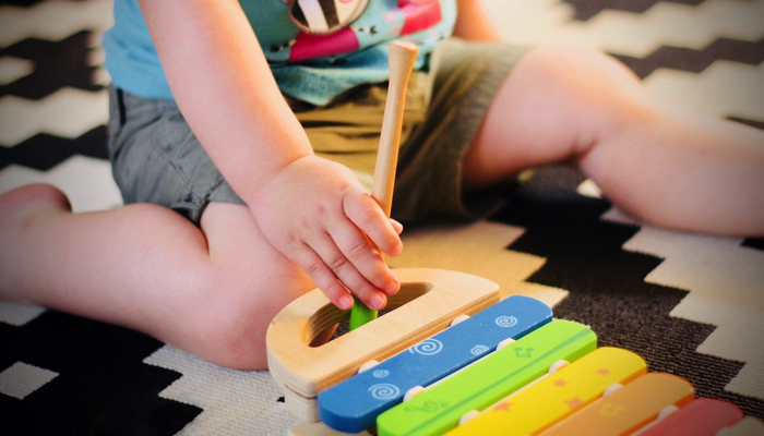 toddler playing with a xylophone