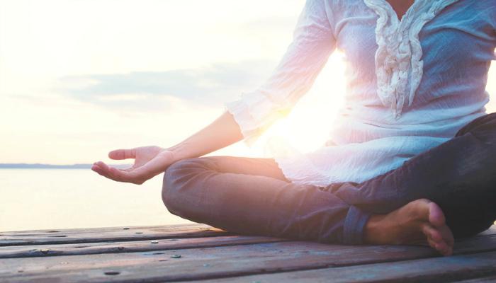 Woman meditating on a dock