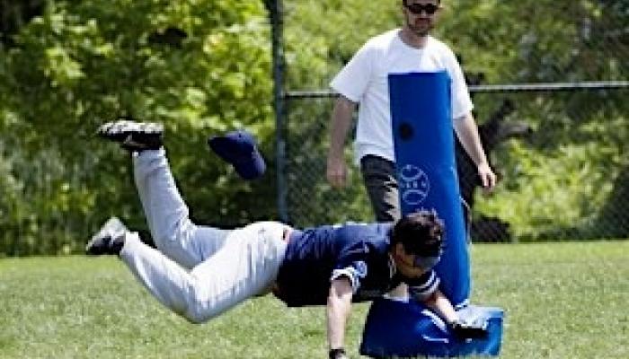 a blind runner dives for the base in beep baseball