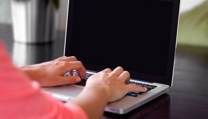 person working at desk with laptop computer