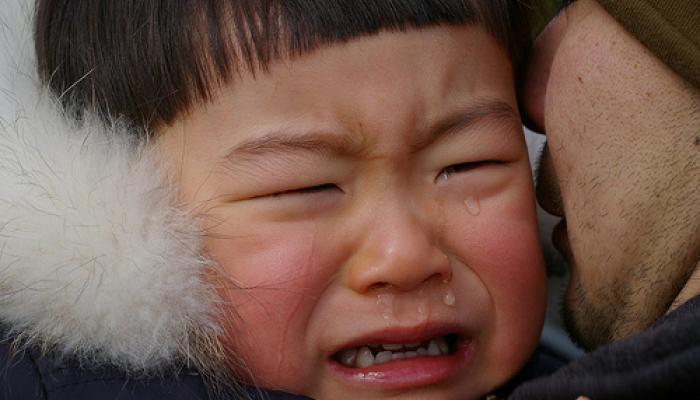 Boy crying near his father's face