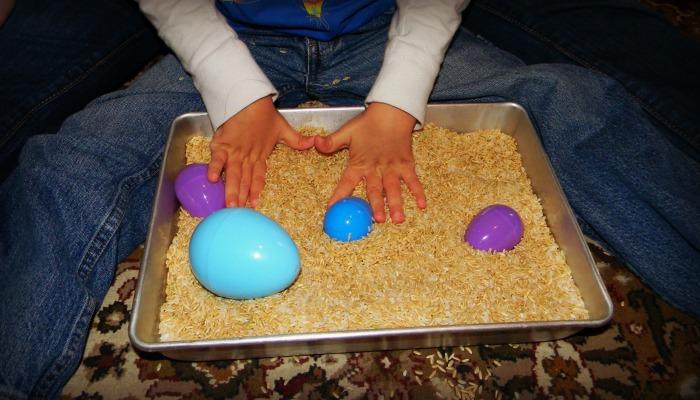 A child's hand trying to find easter egg in sensory egg hunt