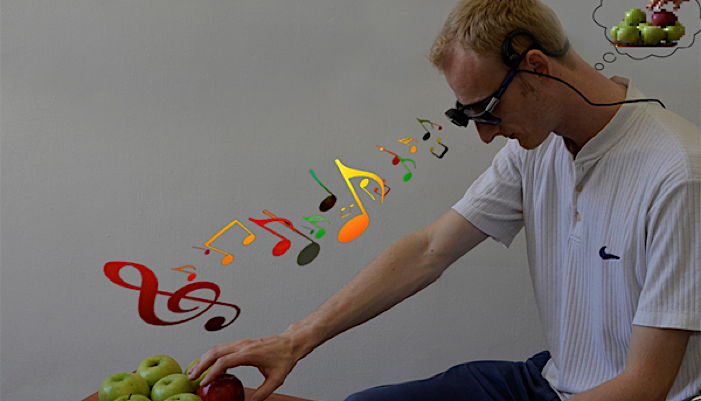 A man using EyeMusic reaches for an apple