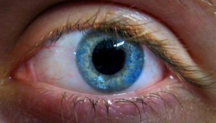 Up close image of a blue eye with wide pupil.