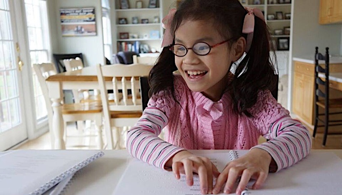 girl reading braille