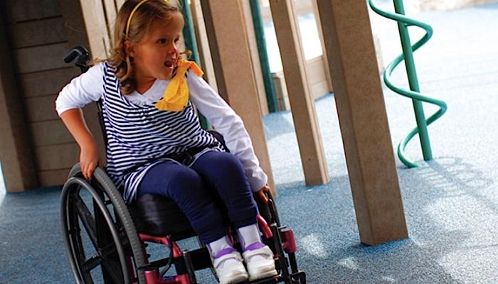 little girl in a wheelchair at the playground