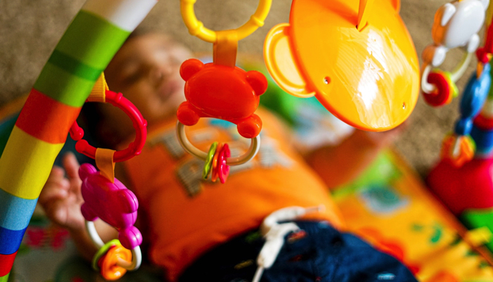 a baby in a play space with hanging toys