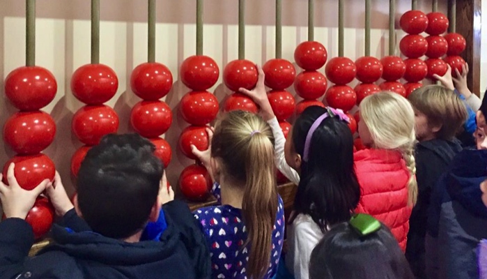 Kids touching a giant abacus