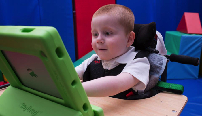 boy in a wheelchair playing on a computer
