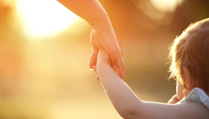 a mom holding hands with her daughter