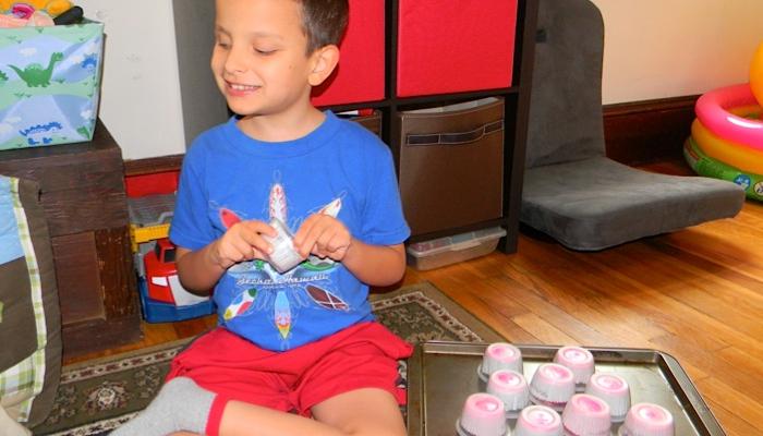 Ivan picking up a cup and playing his tactile matching game