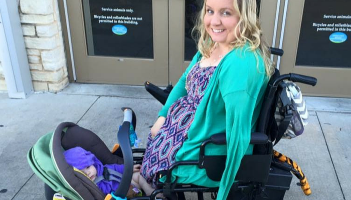 woman in wheelchair with baby carrier attached