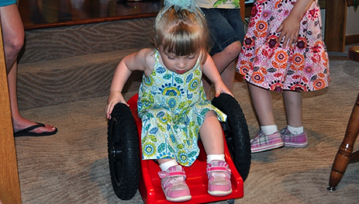 a little girl in her assistive rolling chairs for kids