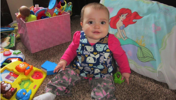 a baby girl wearing vest with recorder