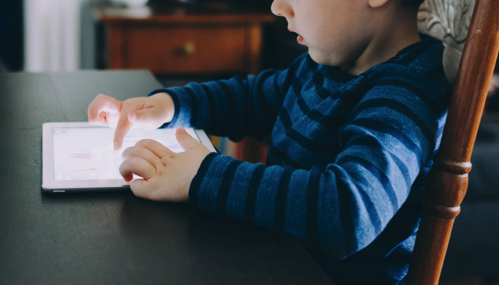 boy sitting at table with an iPad