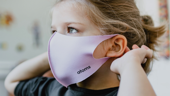 young girl wearing a pink mask