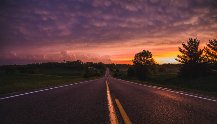 a paved road at sunset