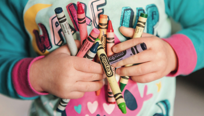 toddler holding crayons