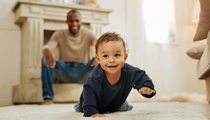 Baby crawling with dad.