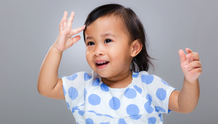 little girl doing sign language