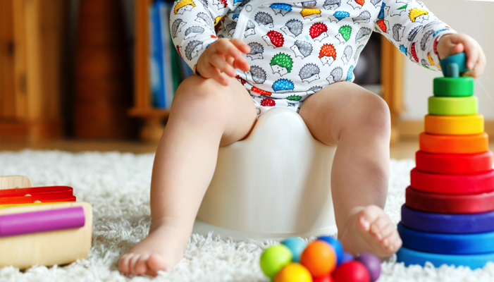 Toddler sitting on a potty chair.