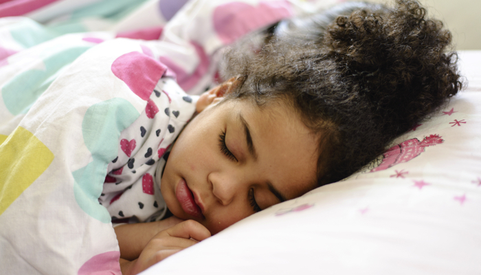 little girl sleeping in bed