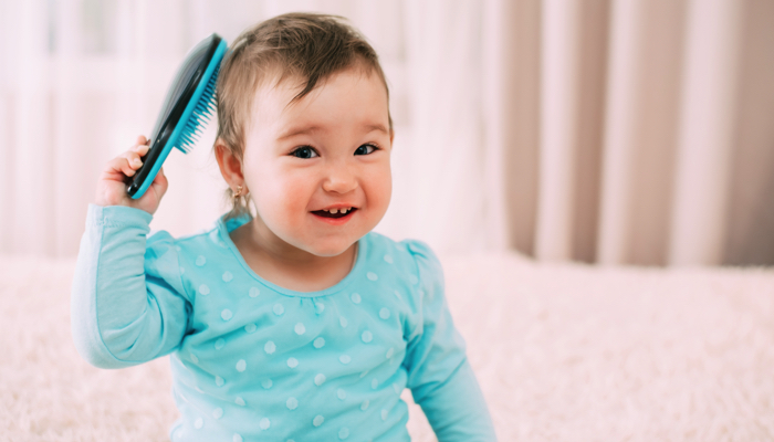 baby brushing her hair